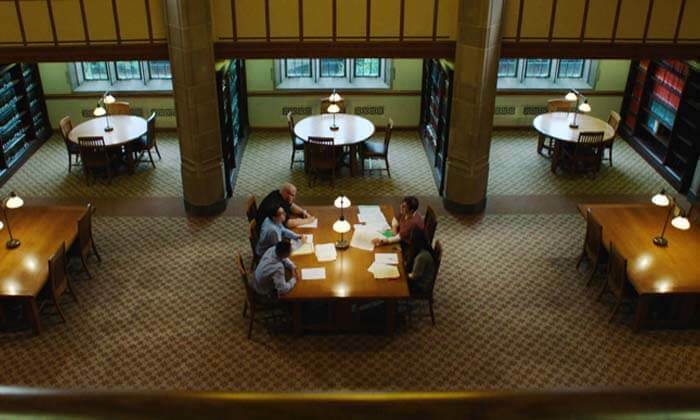 Judith Fox sits with her team at a table in the Notre Dame Law School library.
