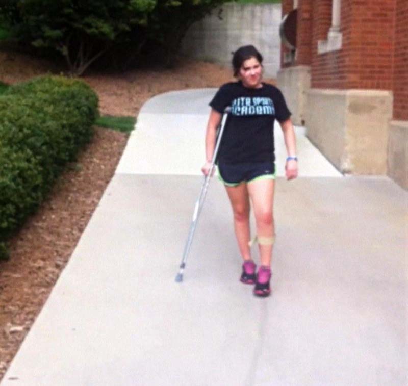 Marissa walking with a crutch.