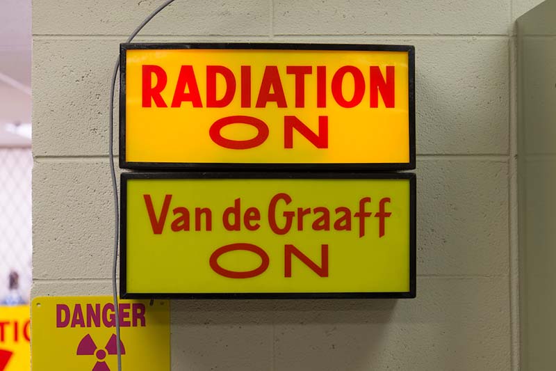 Signs outside the Rad Lab, reading Radiation On, Van deGraaff On, Danger High Radiation Area.