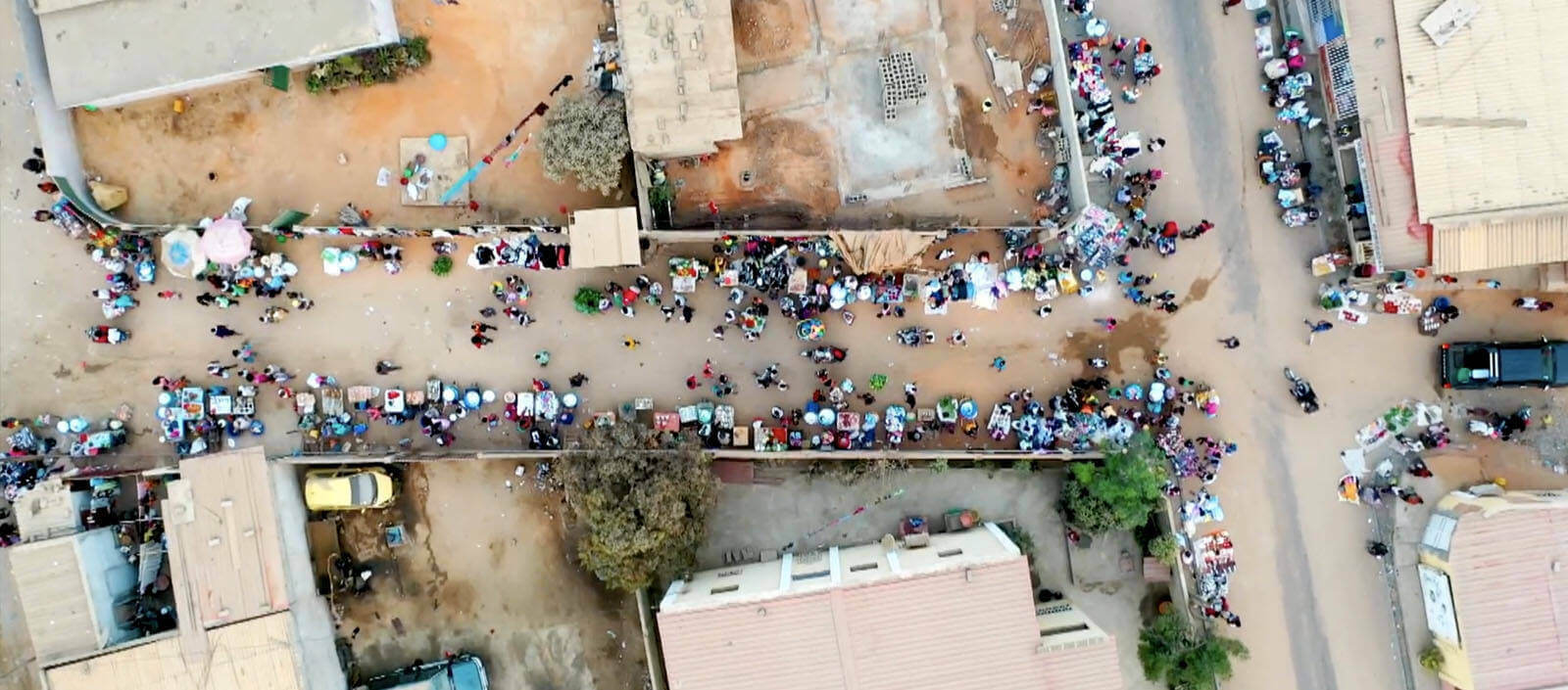 Aerial of people wandering around a market in Angola, Africa