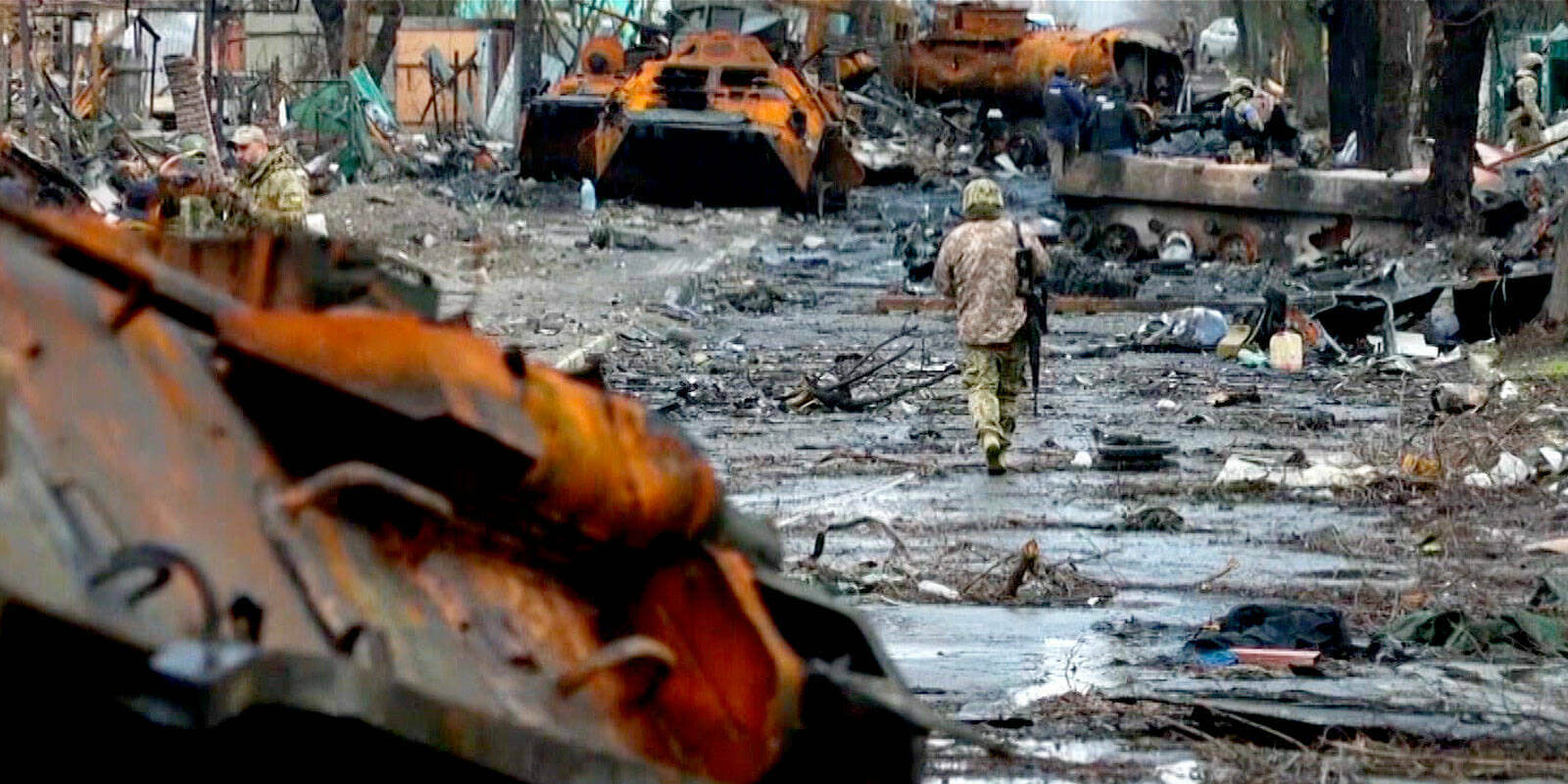 A soldier walks through destruction in Ukraine.