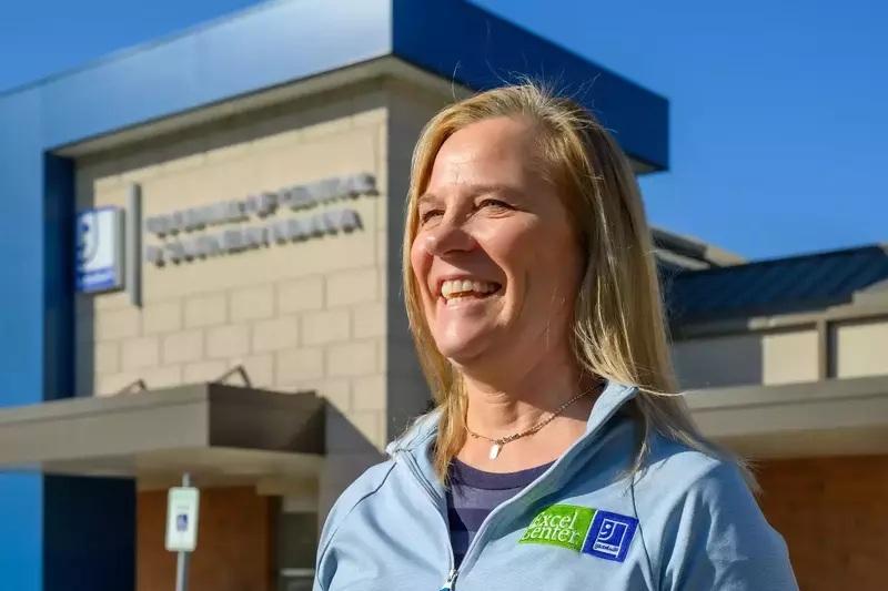 Betsy Delgado smiling in front of a Goodwill storefront