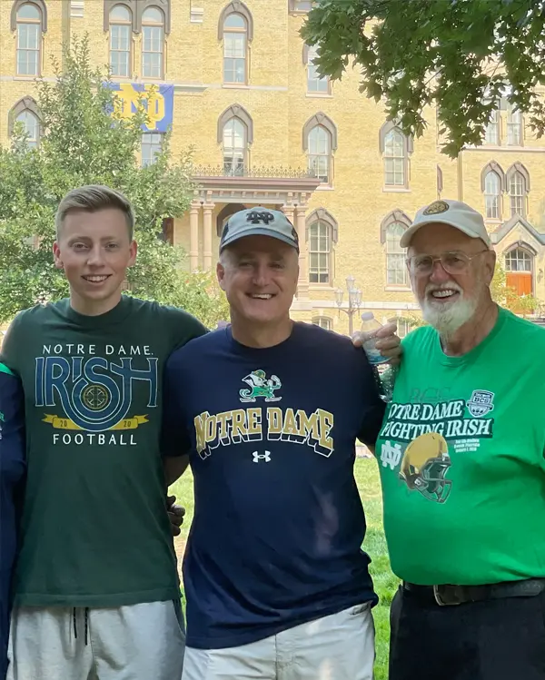 Richard McManus stands with his father and grandfather on campus. 