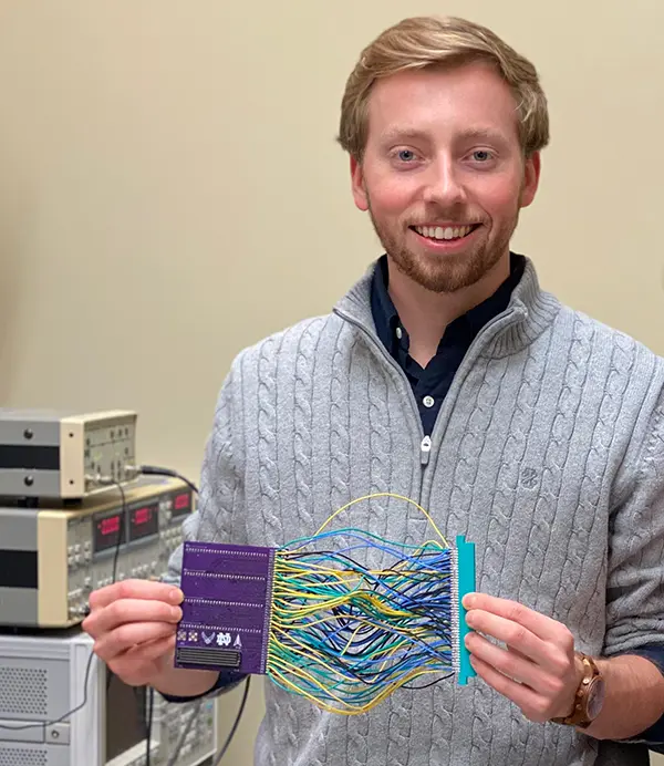 Richard McManus holds up a series of colorful wires 