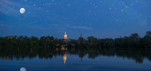 A view from Saint Joseph Lake showing a reflection of the main building and Basilica on the campus of the University of Notre Dame.