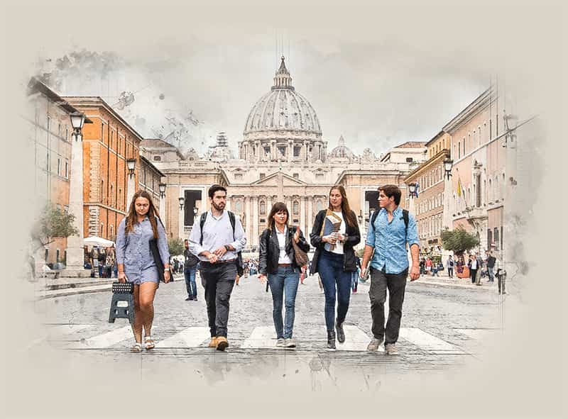 Five people walk towards the camera with buildings behind them.