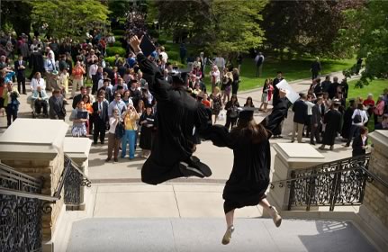 Students celebrate graduation on the steps of the Main Building.